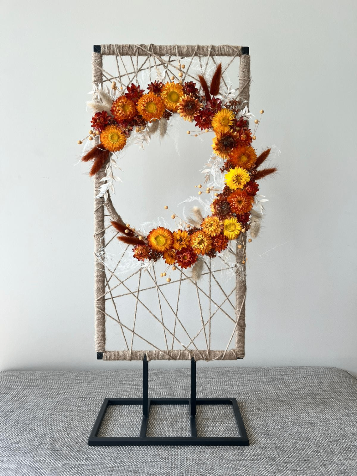 Workshop creatie met droogbloemen in een frame met rode en gele bloemen