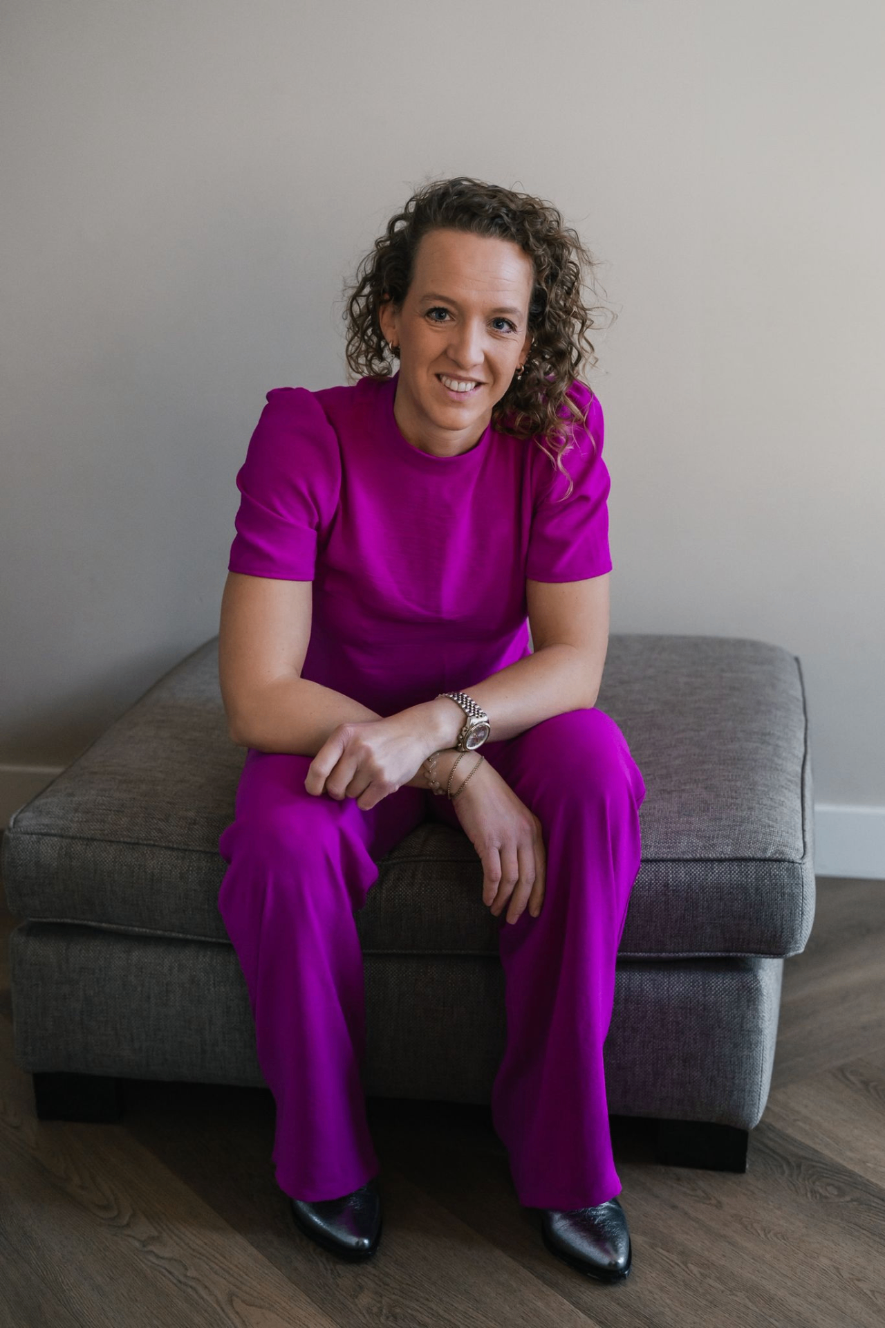 Linda van de Ven zittend in een roze outfit